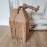 cale porte en chêne naturel. Inscription ILE D'YEU peinte en gris foncé sur le devant. Une grosse corde en jute est nouée sur le dessus