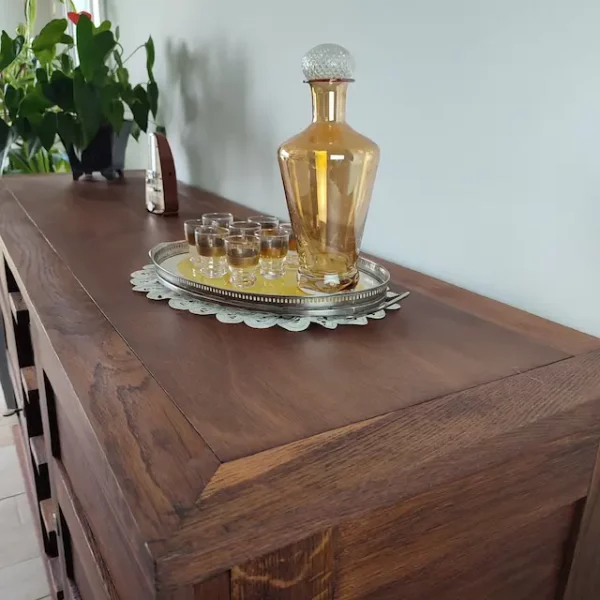 Buffet René gabriel restauré. Détail du plateau refait par application d'un nouveau placage. Un service à liqueur des années 60 est posé sur le meuble.