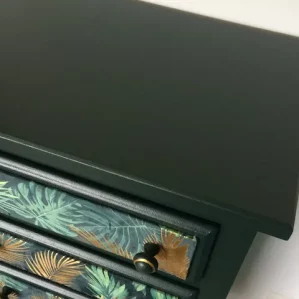 chiffonnier 5 tiroirs restauré. Peint en vert forêt et application d'un tissu "feuillage" sur les tiroirs