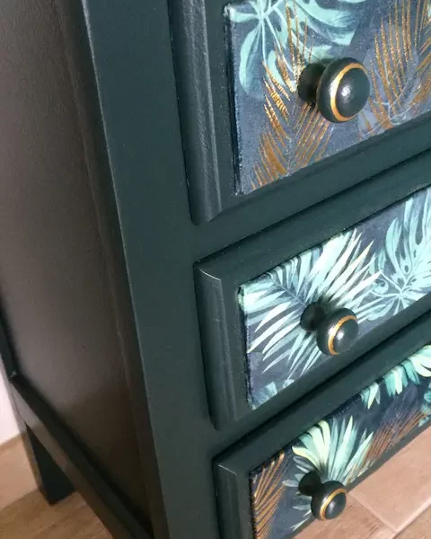 chiffonnier 5 tiroirs restauré. Peint en vert forêt et application d'un tissu "feuillage" sur les tiroirs