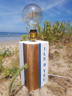 lampe à poser en bois recyclé sur laquelle est inscrit Ile d'Yeu. La photo de la lampe est prise à Port Joinville, à l'île d'Yeu.