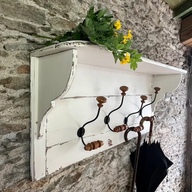 Ancien porte manteau et chapeau en bois rénové. Peinture blanche patiné effet vieilli. 5 patères doubles anciennes de 1900. Photon mur en pierres apparaentes.