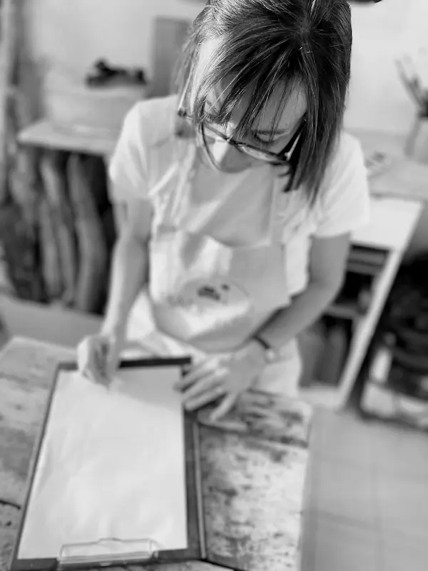 portrait en noir et blanc de sophie denis à dessiner dans son atelier