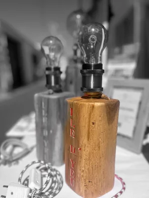 Photo pour moitié en noir et blanc et l'autre moitié en couleur. On voit deux lampes en bois avec une ampoule