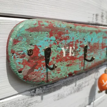 porte clé mural réalisé avec un bois flotté. Peinture patinée en vert et rouge.